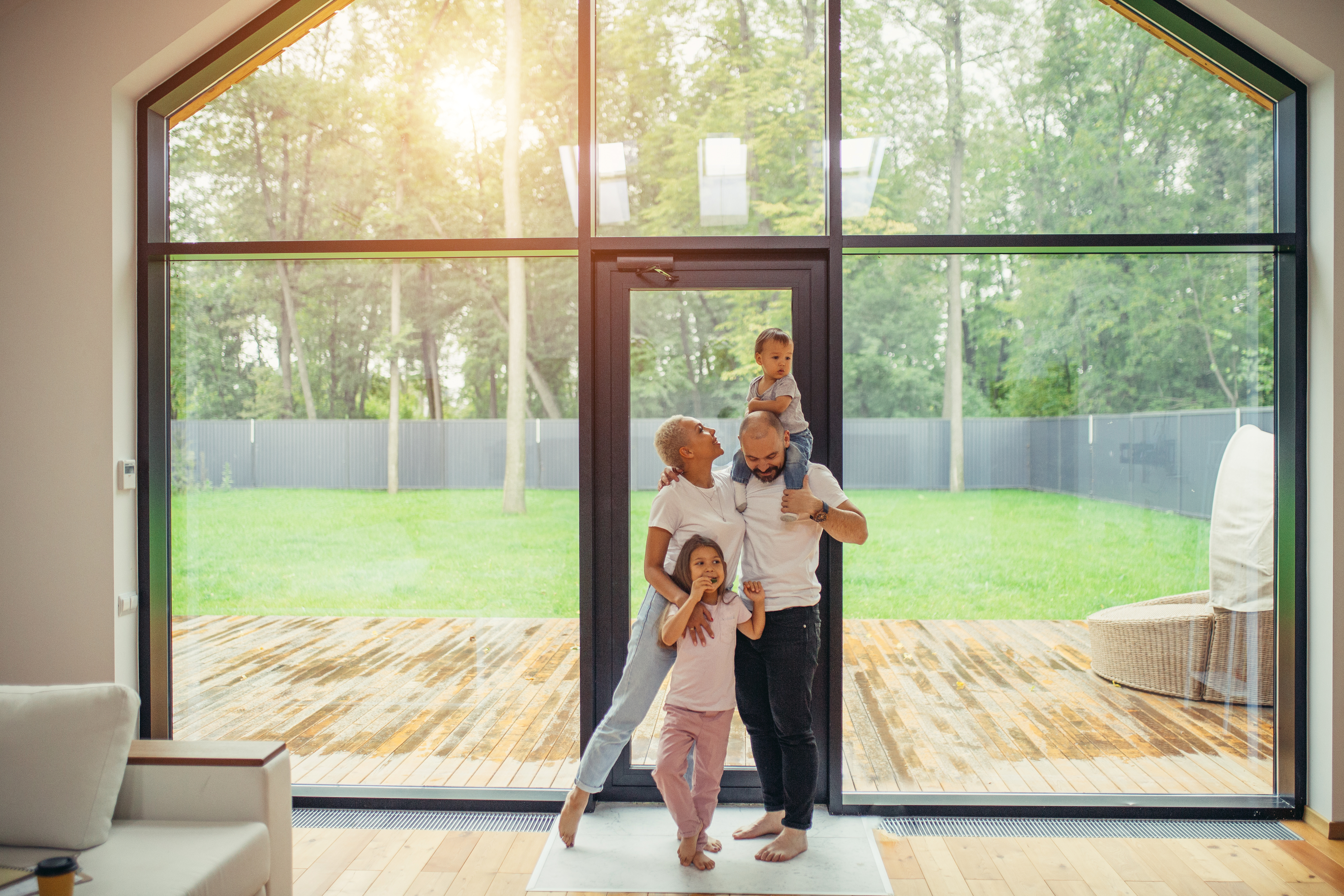 Beautiful and happy family together at home with panoramic window standing
