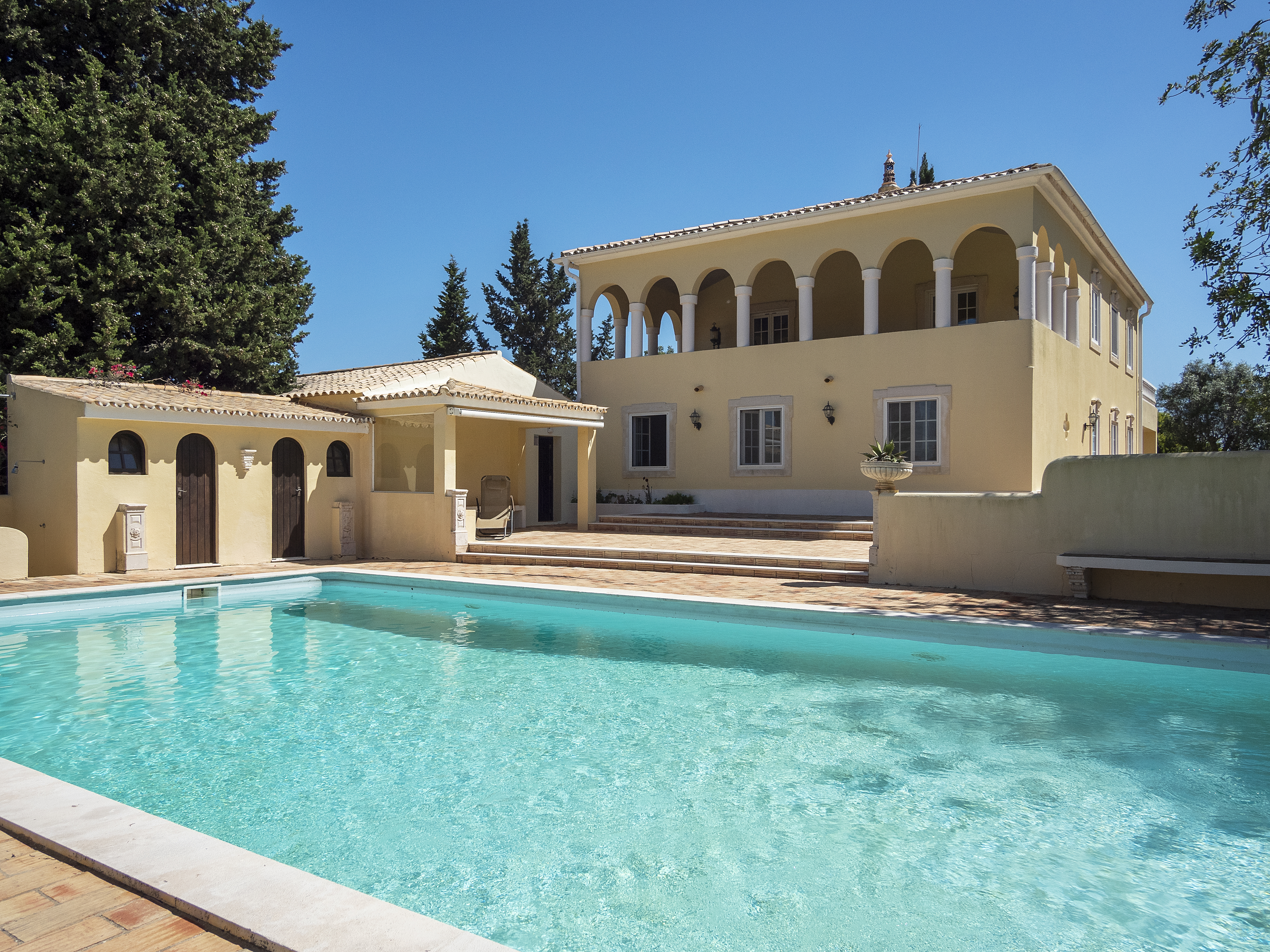 grand luxury yellow villa in Portugal with pillars and swimming pool