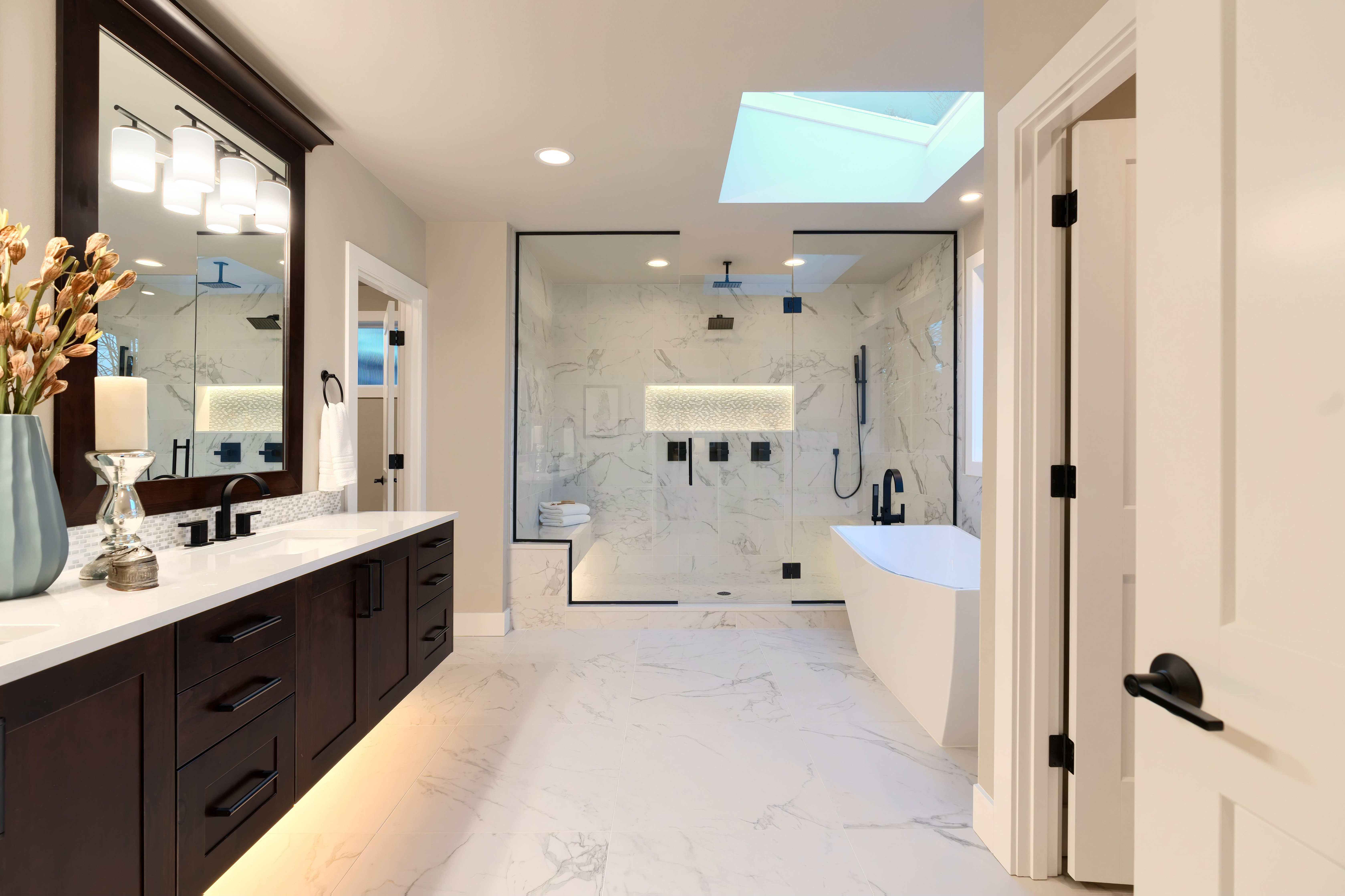 luxury_modern_home_bathroom_interior_with_dark_brown_cabinets_white_marble_walk_in_shower_free_standing_tub