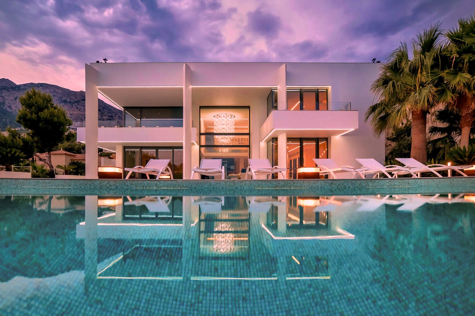 luxury prestigious modern contemporary villa chandelier at sunset swimming pool