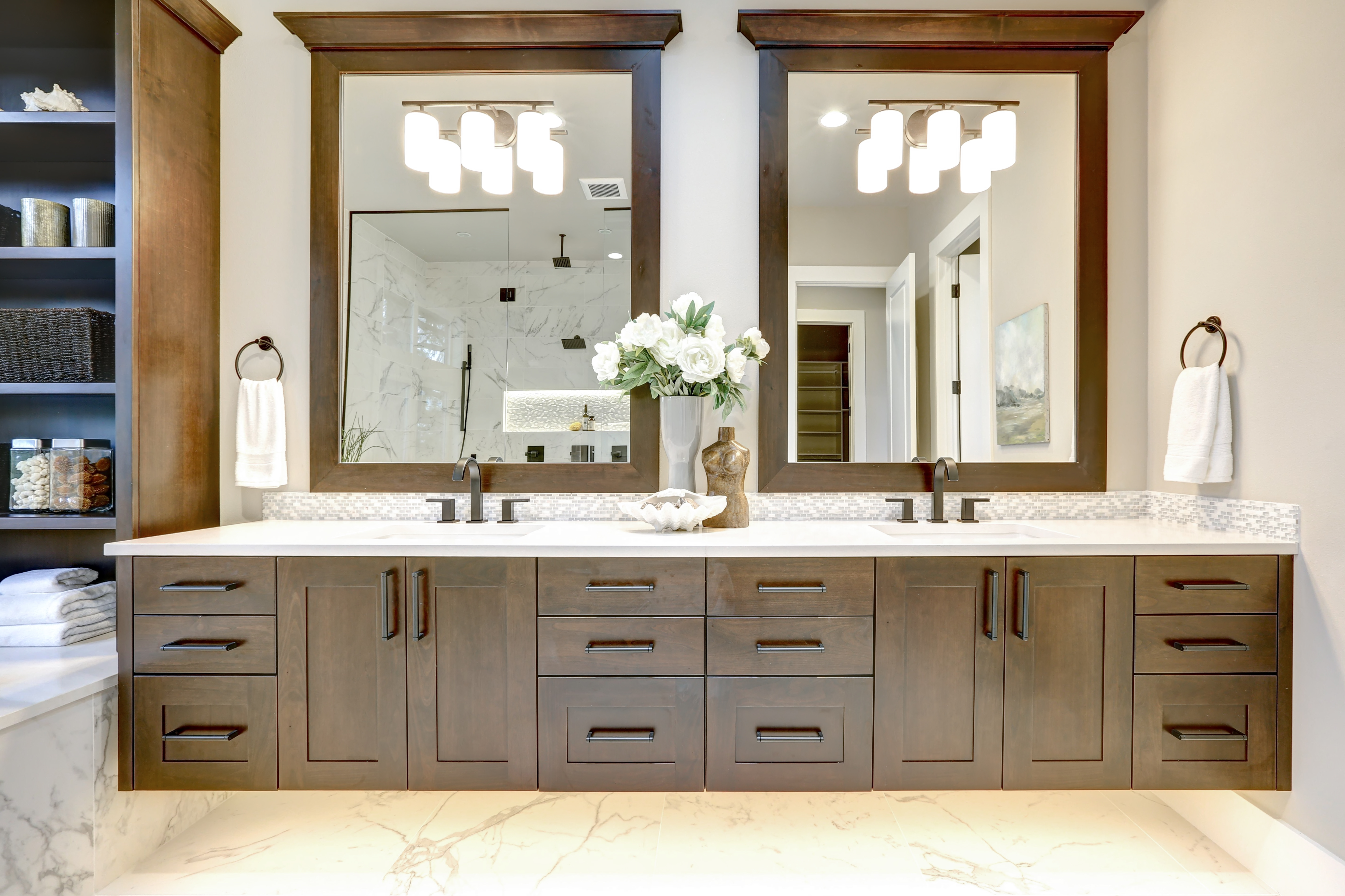 master_bathroom_interior_in_luxury_modern_home_with_dark_hardwood_cabinets_white_tub_and_glass_door_shower