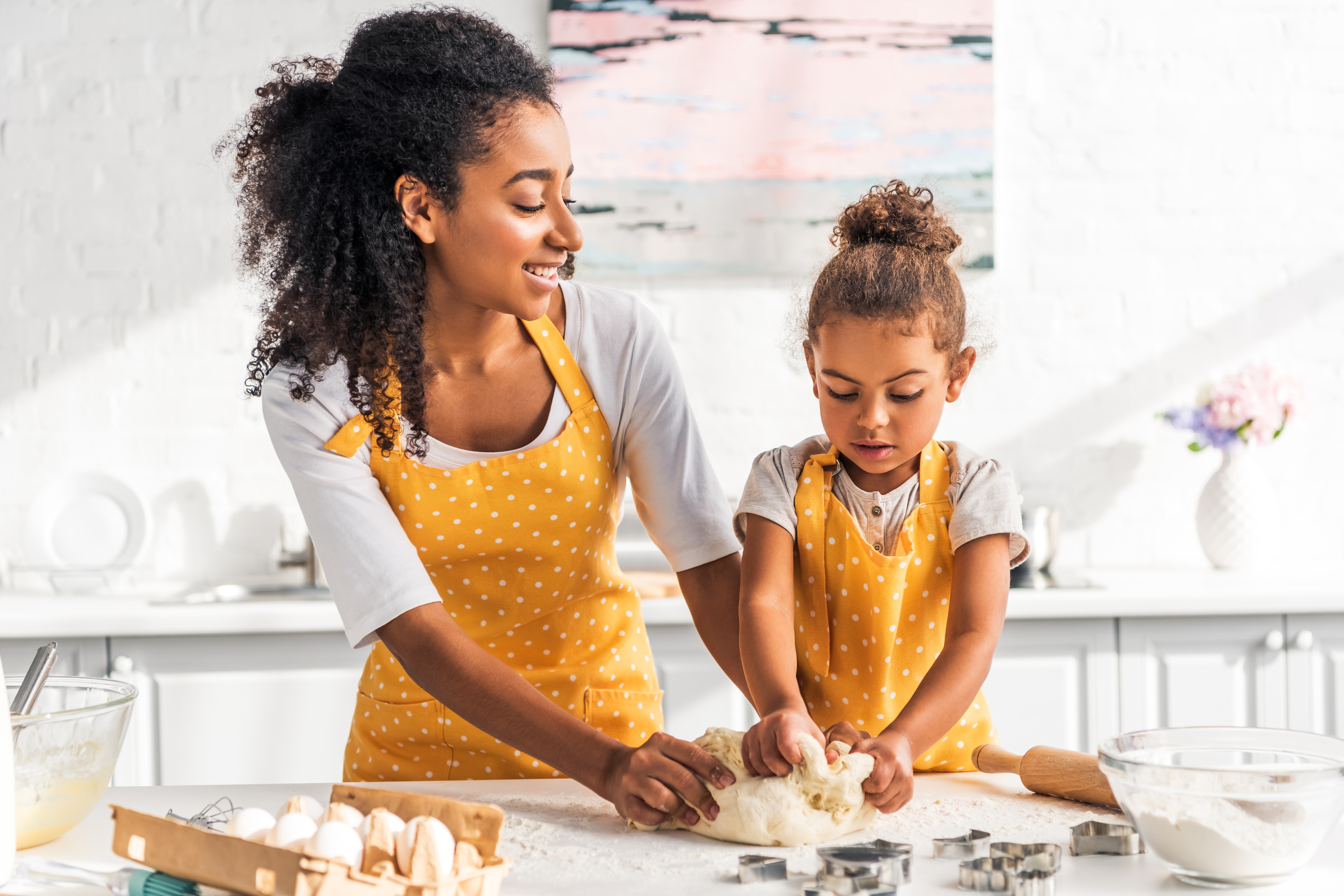 mother_and_daughter_kneading_dough_in_kitchen