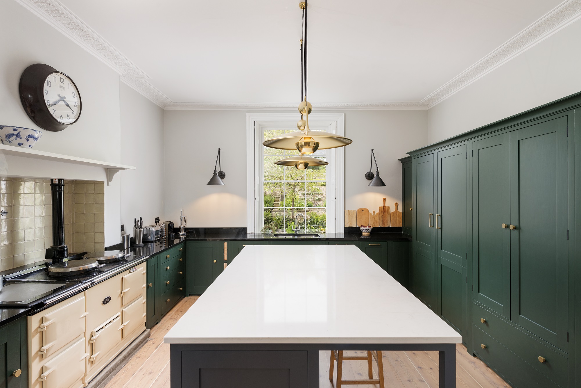gold pendant light in green shaker kitchen with island