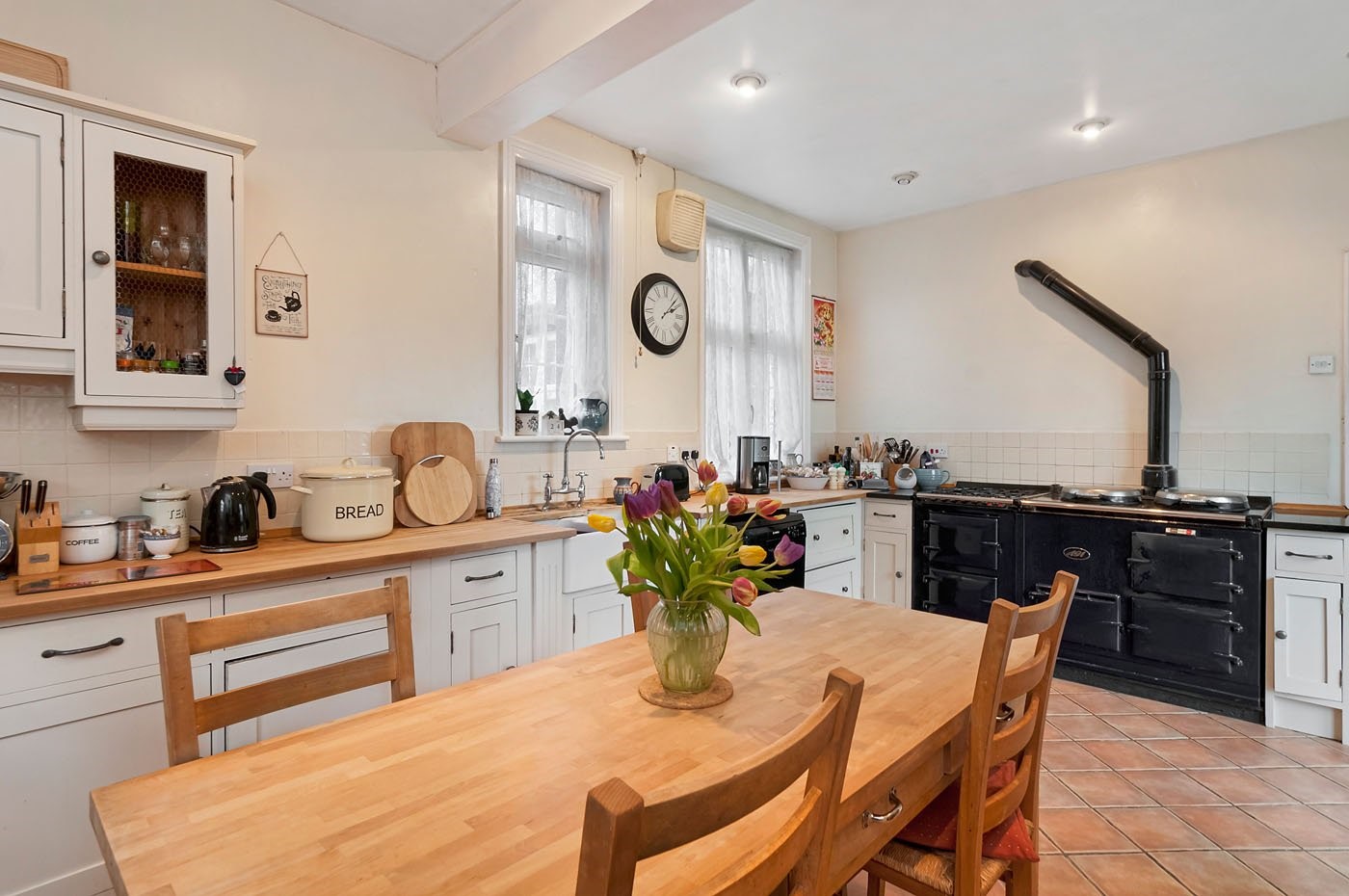 traditional english farmhouse family kitchen with aga terracotta floors