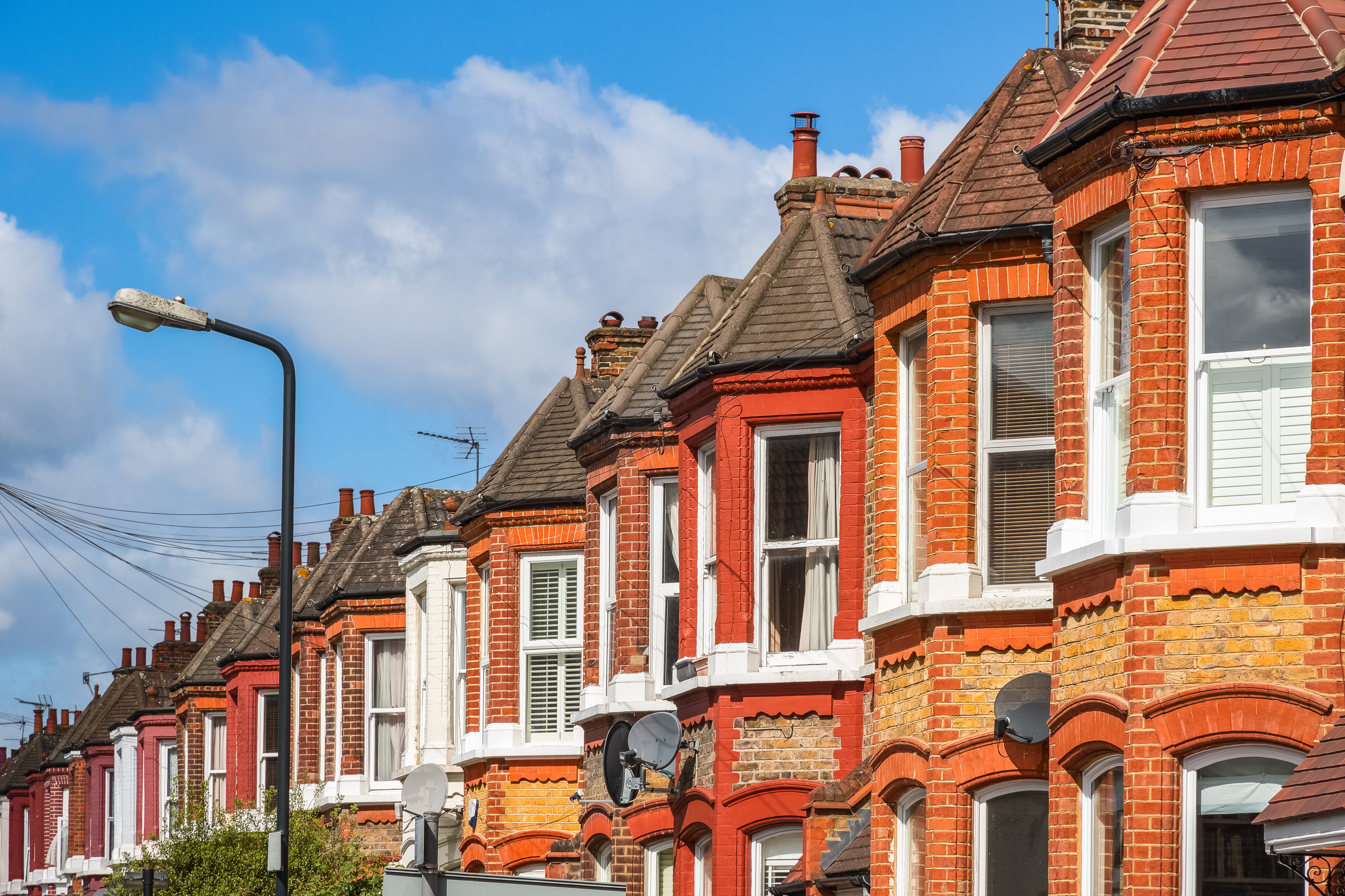 A row of typical red brick British terraced houses in London