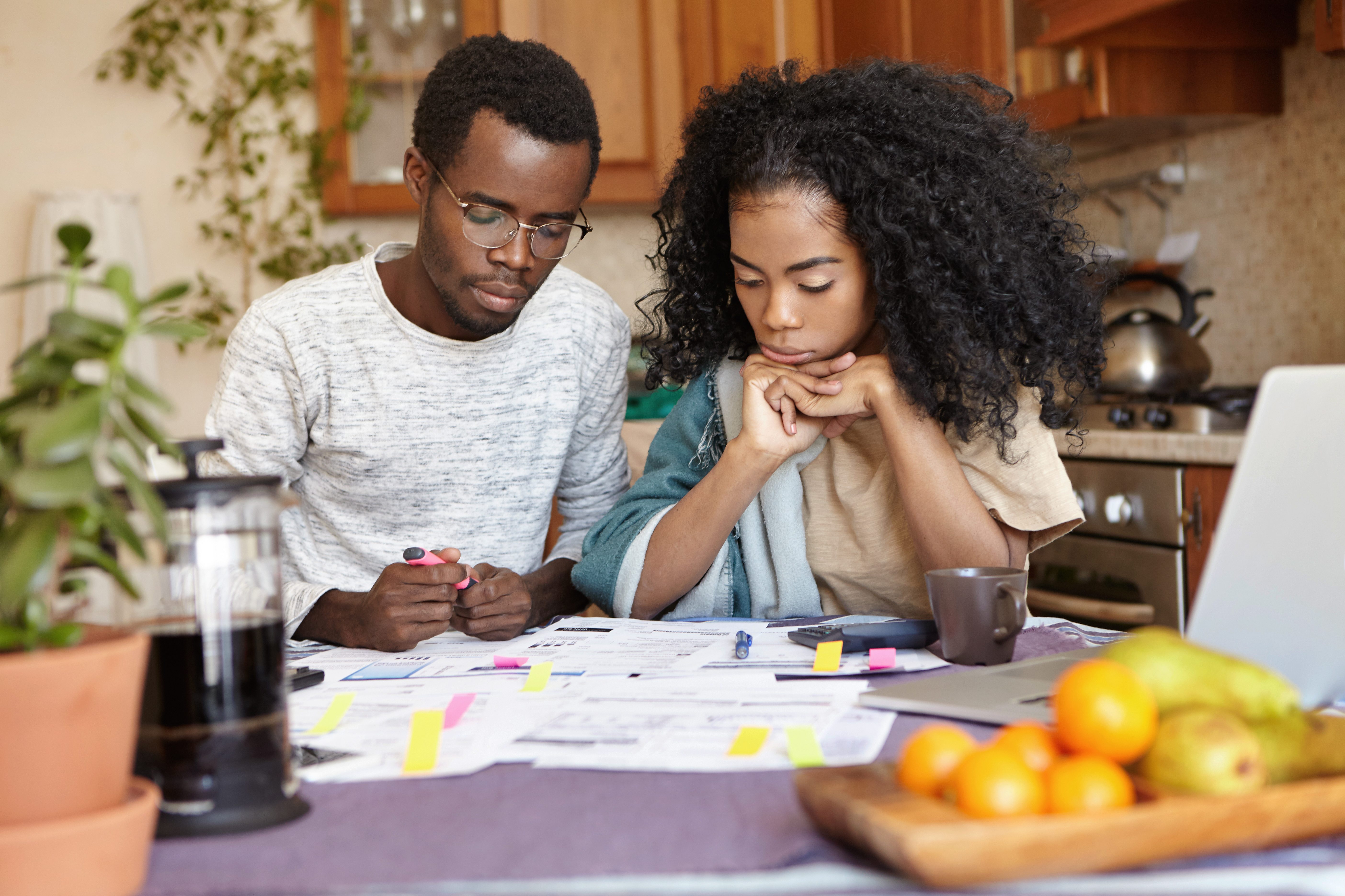 couple doing paperwork together, sitting at kitchen table