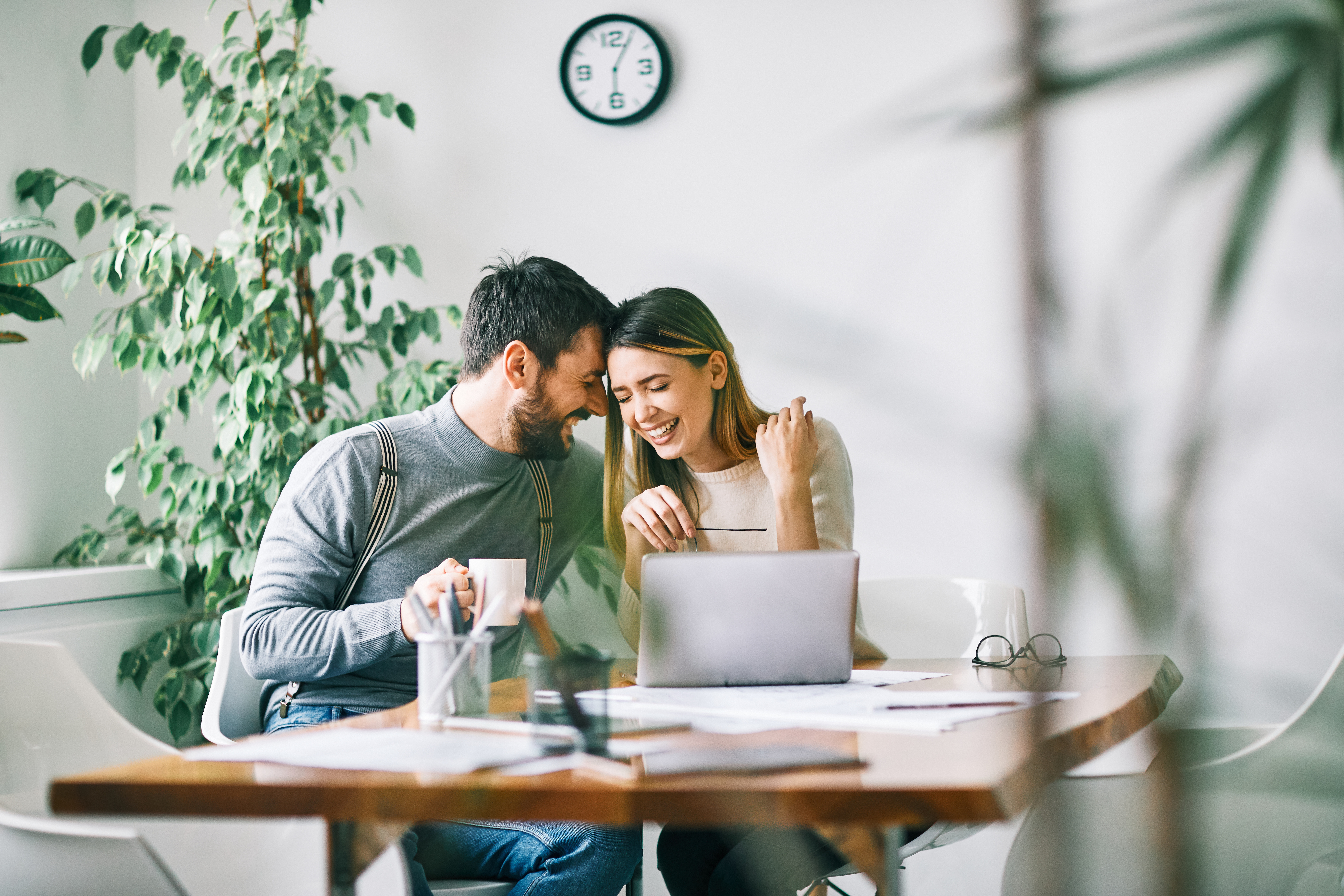 happy couple house hunting on laptop