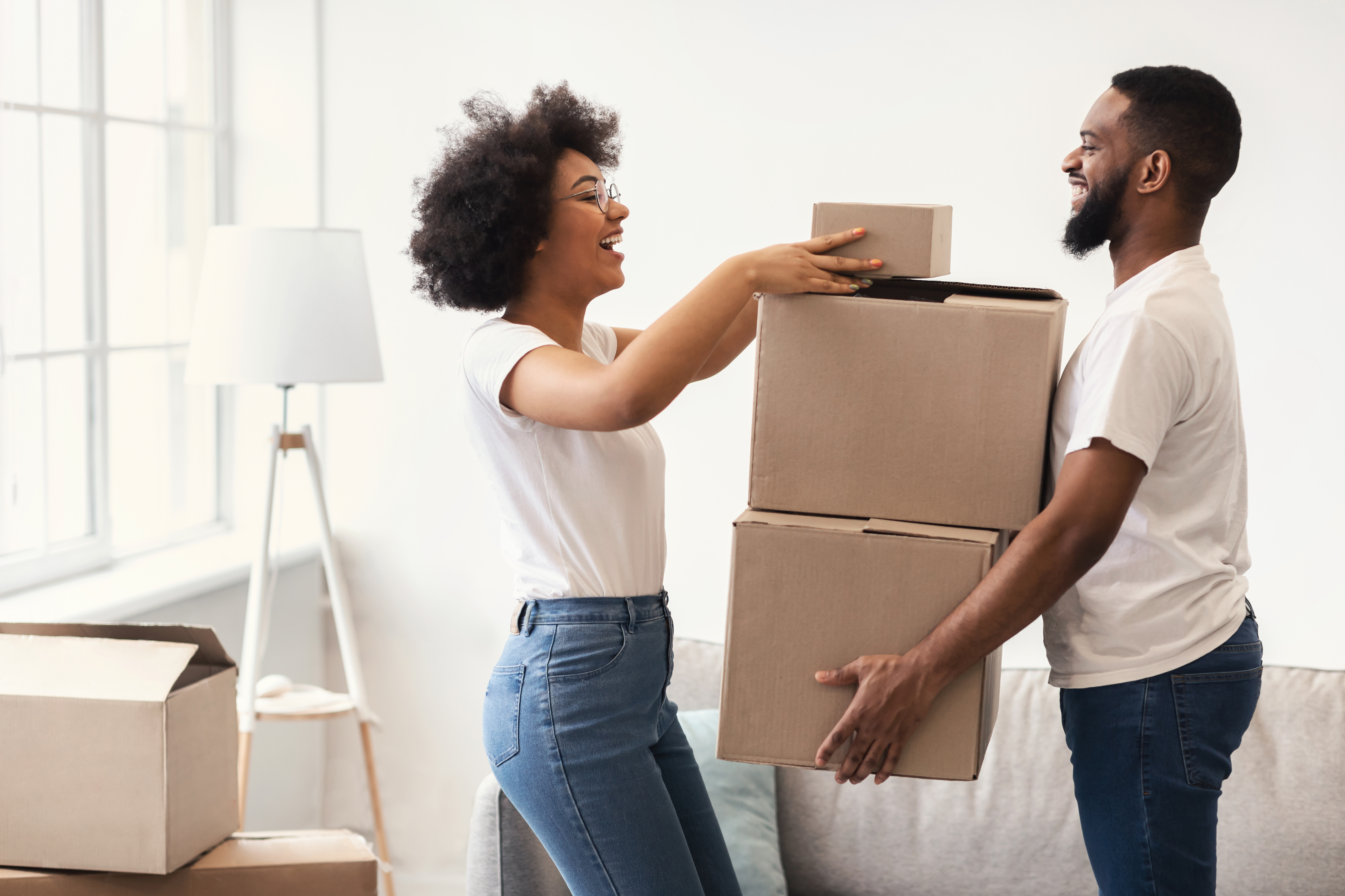 Happy Couple Packing Moving Boxes Together Standing Indoors