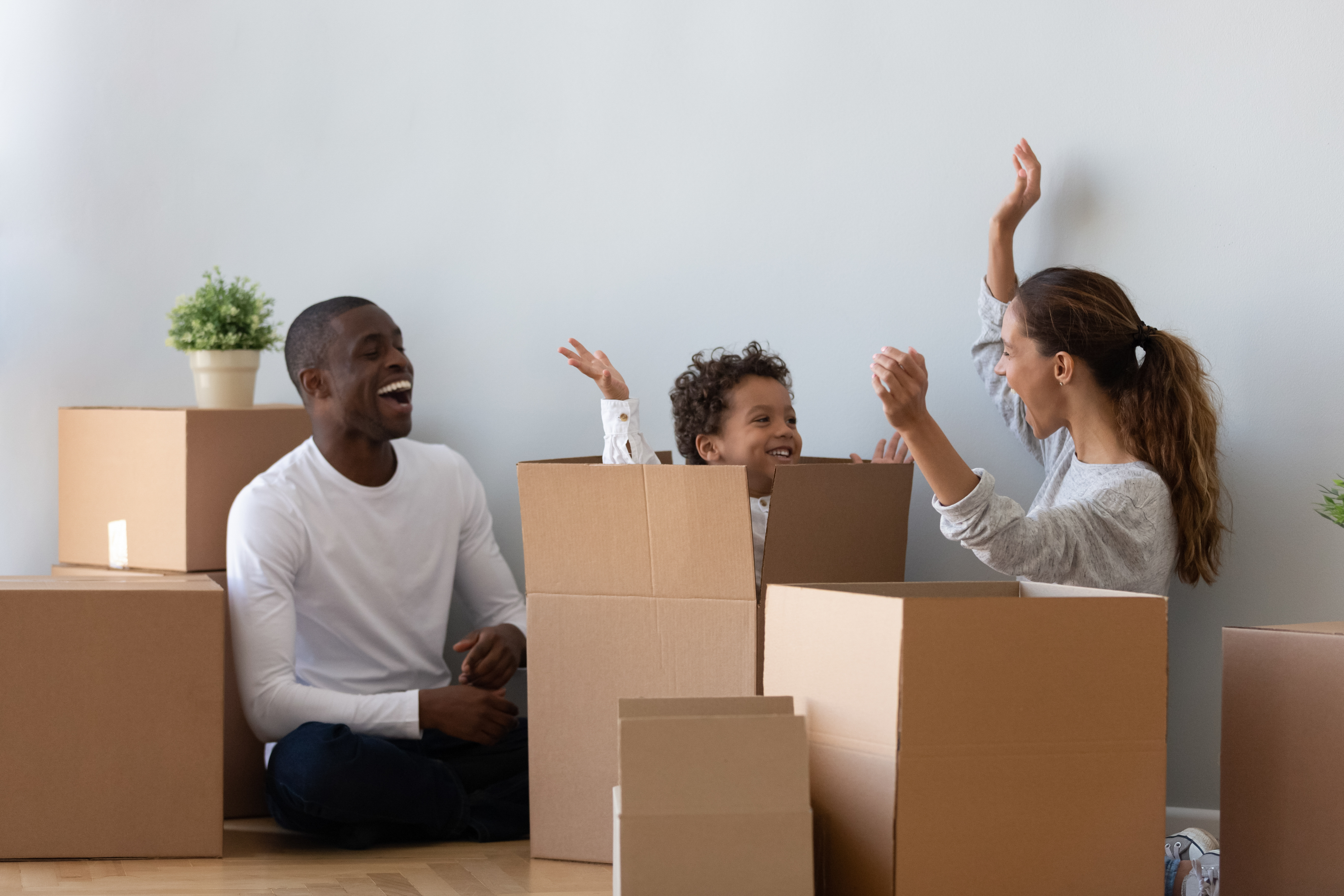 Happy family playing on moving day unpacking boxes