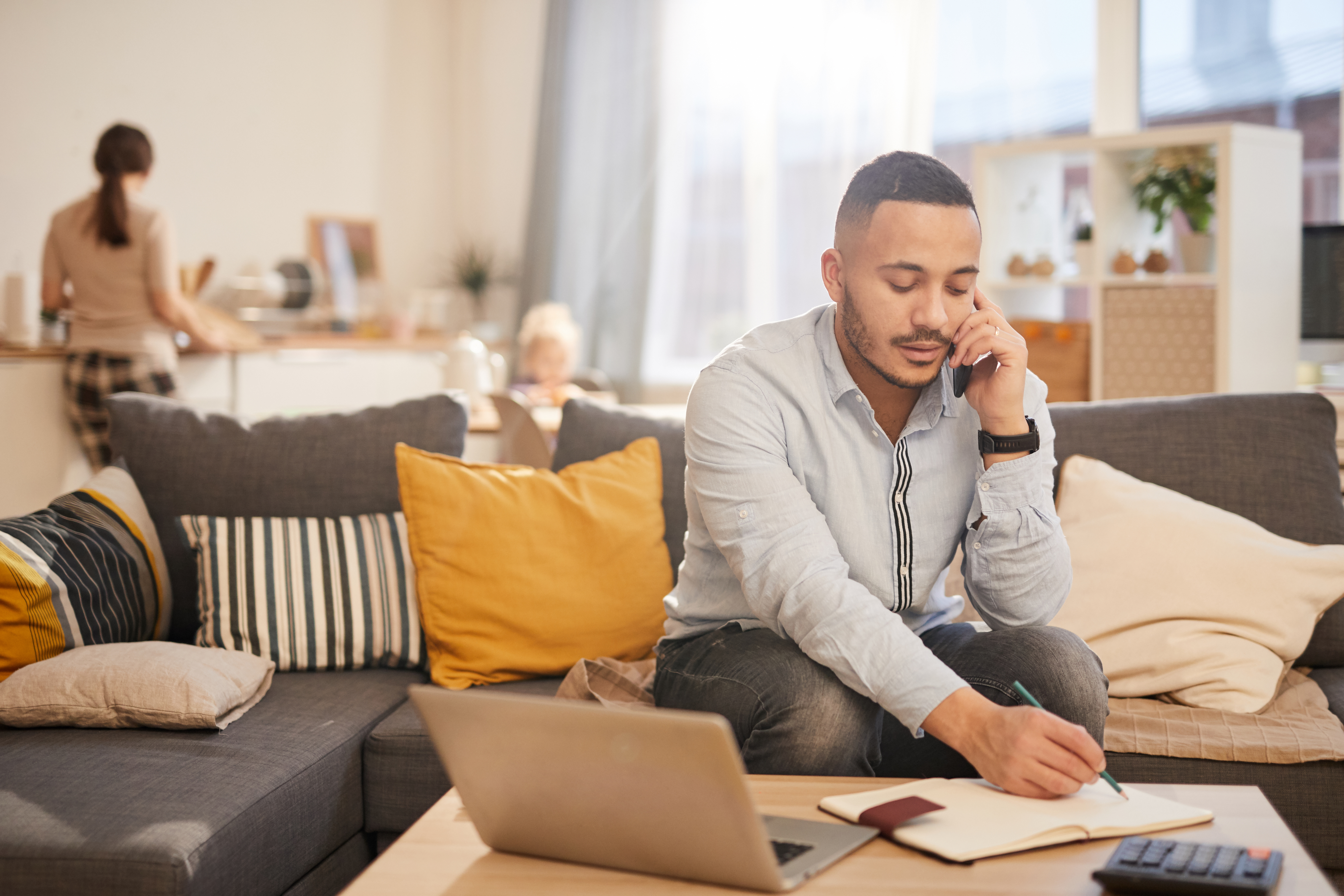  man speaking by phone while working from home in cozy interior, copy space