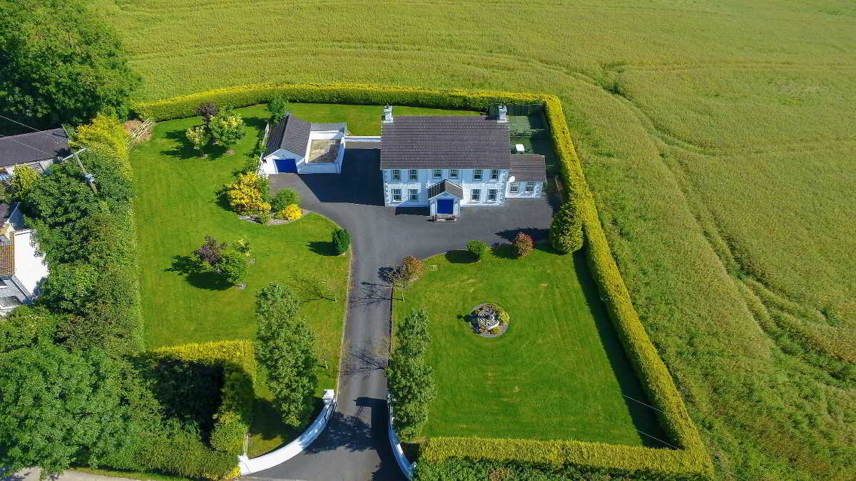 northern ireland contemporary country farmhouse in lush green countryside aerial