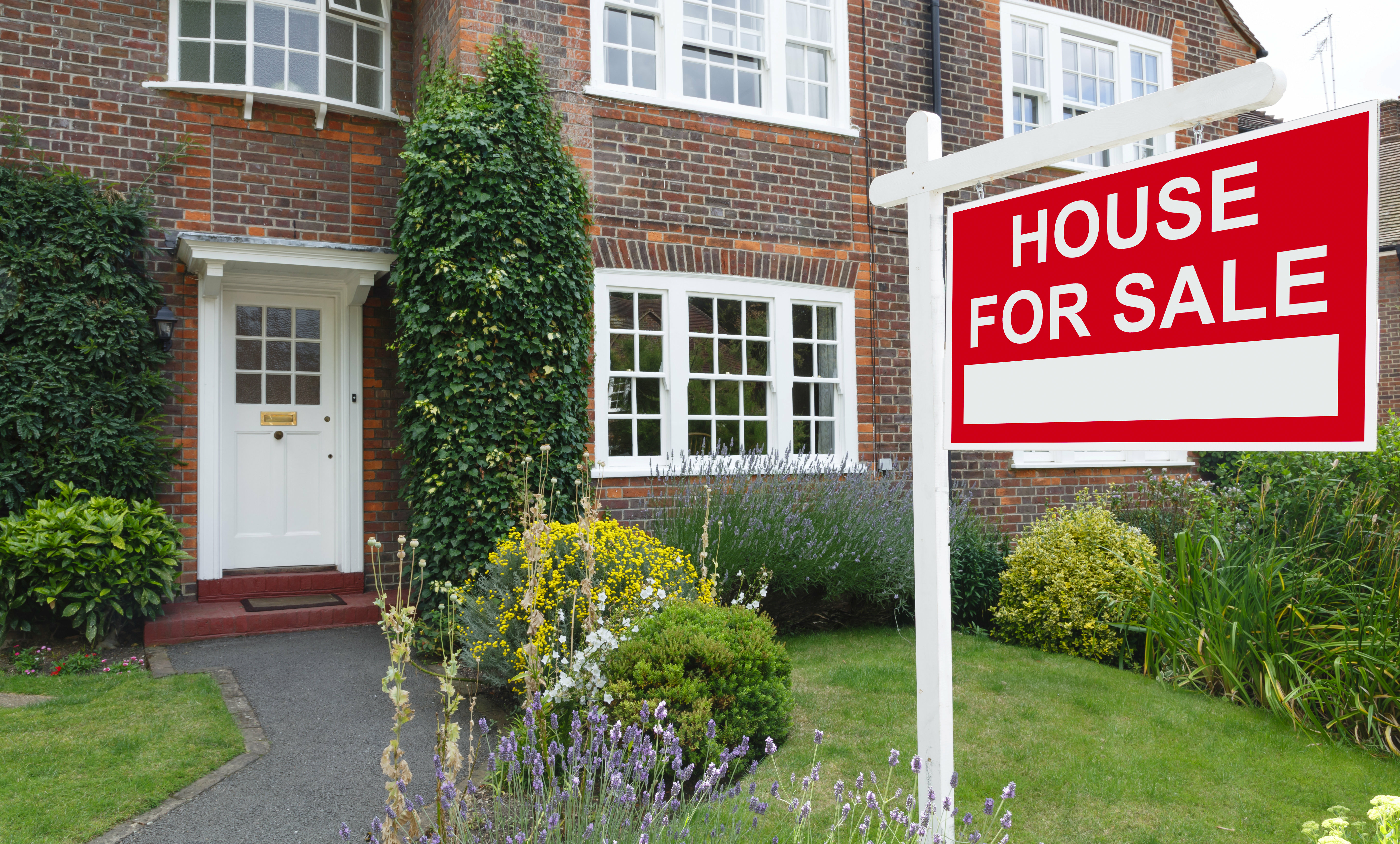 pretty house for sale sign front garden