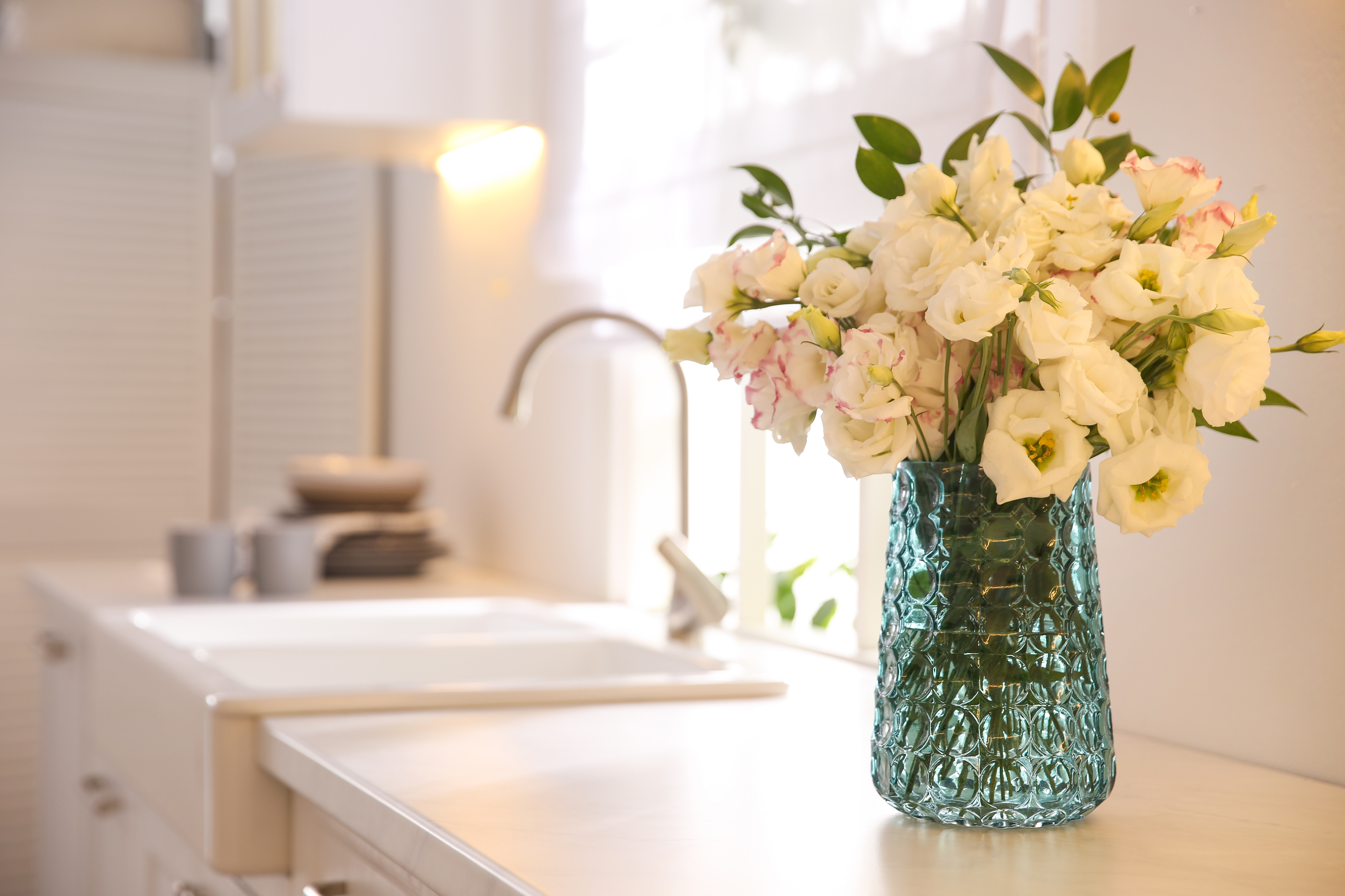 white roses flowers in vase in kitchen of house