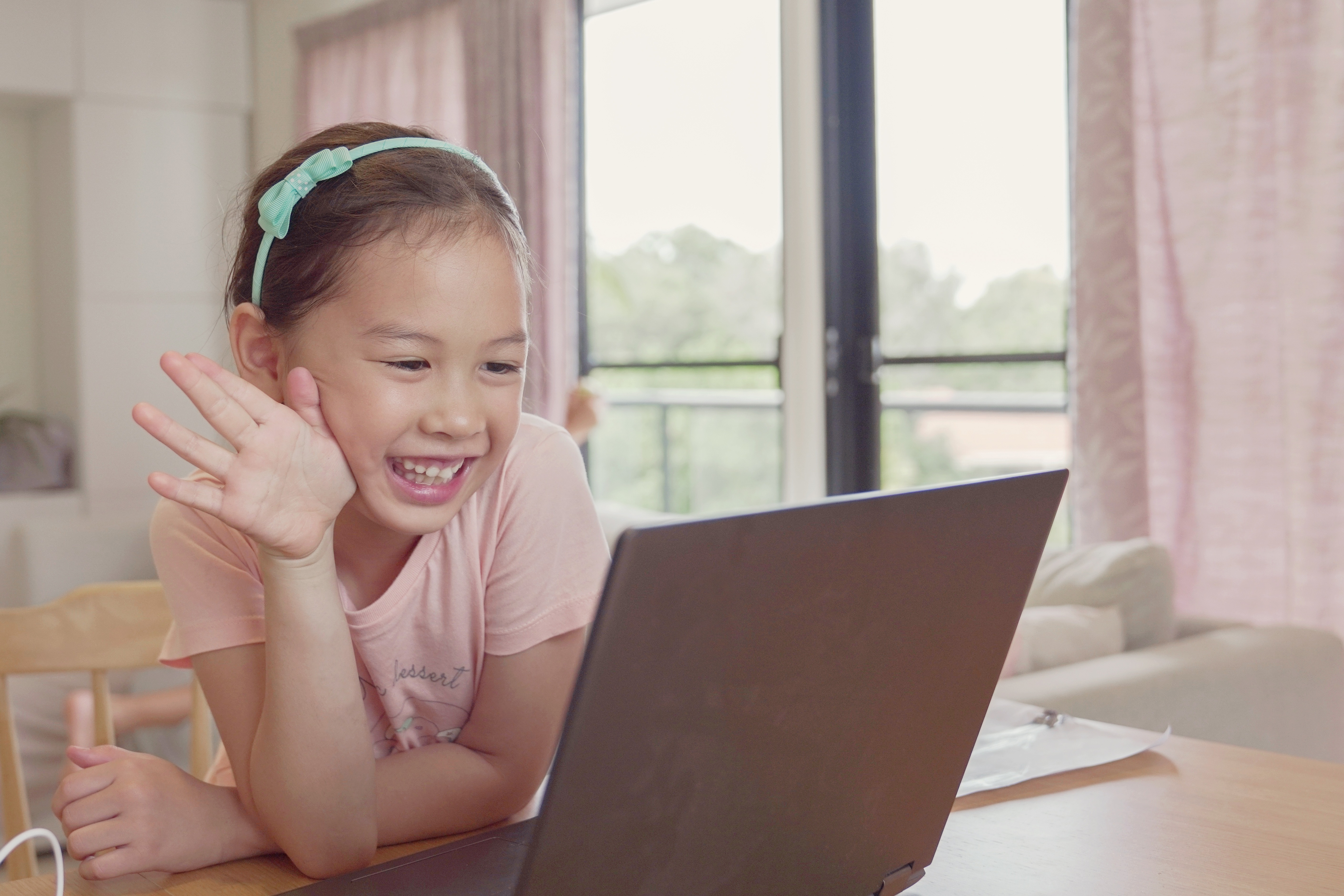 young_girl_waving_at_computer_screen