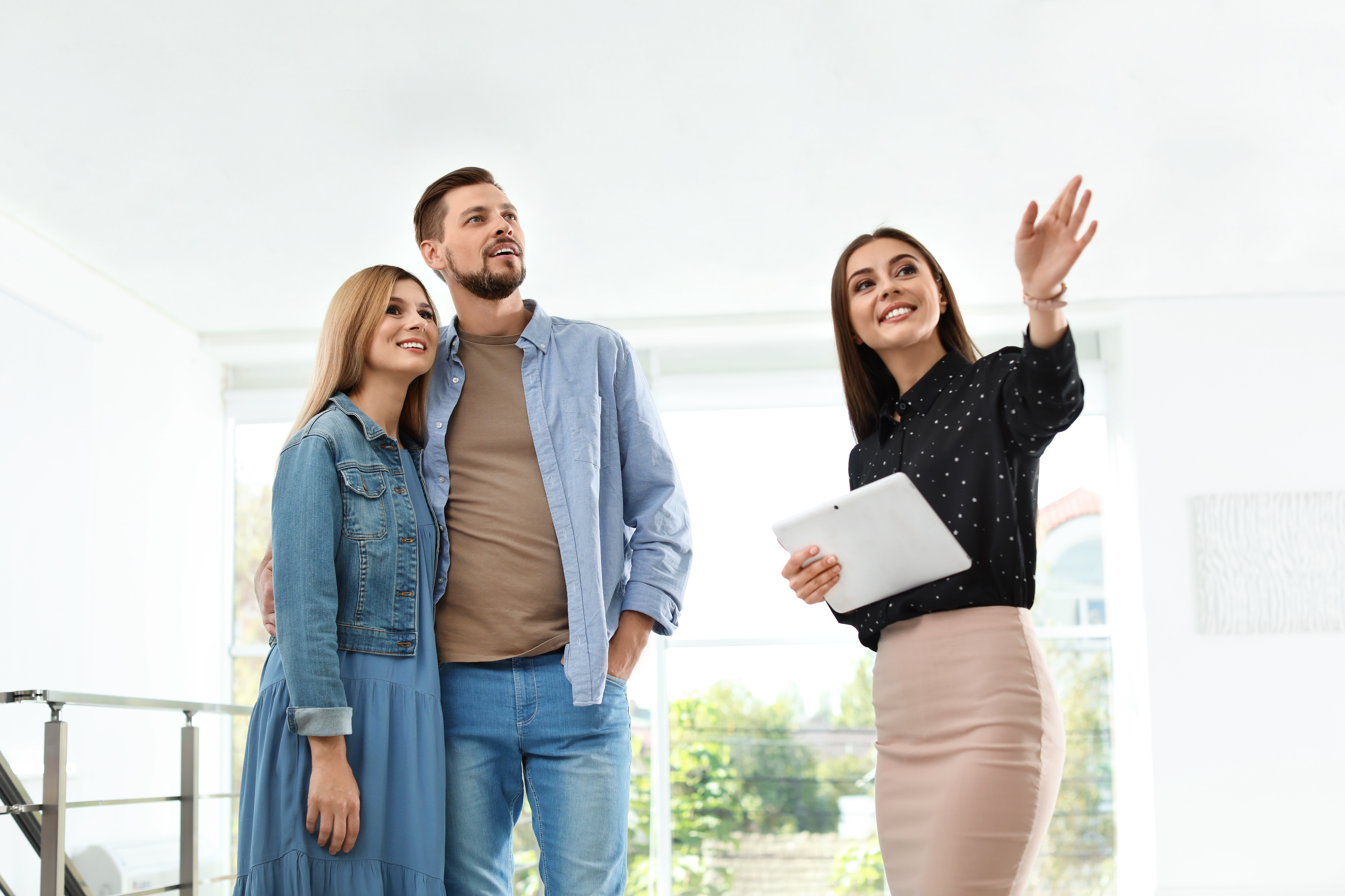 Female real estate agent showing new house to couple