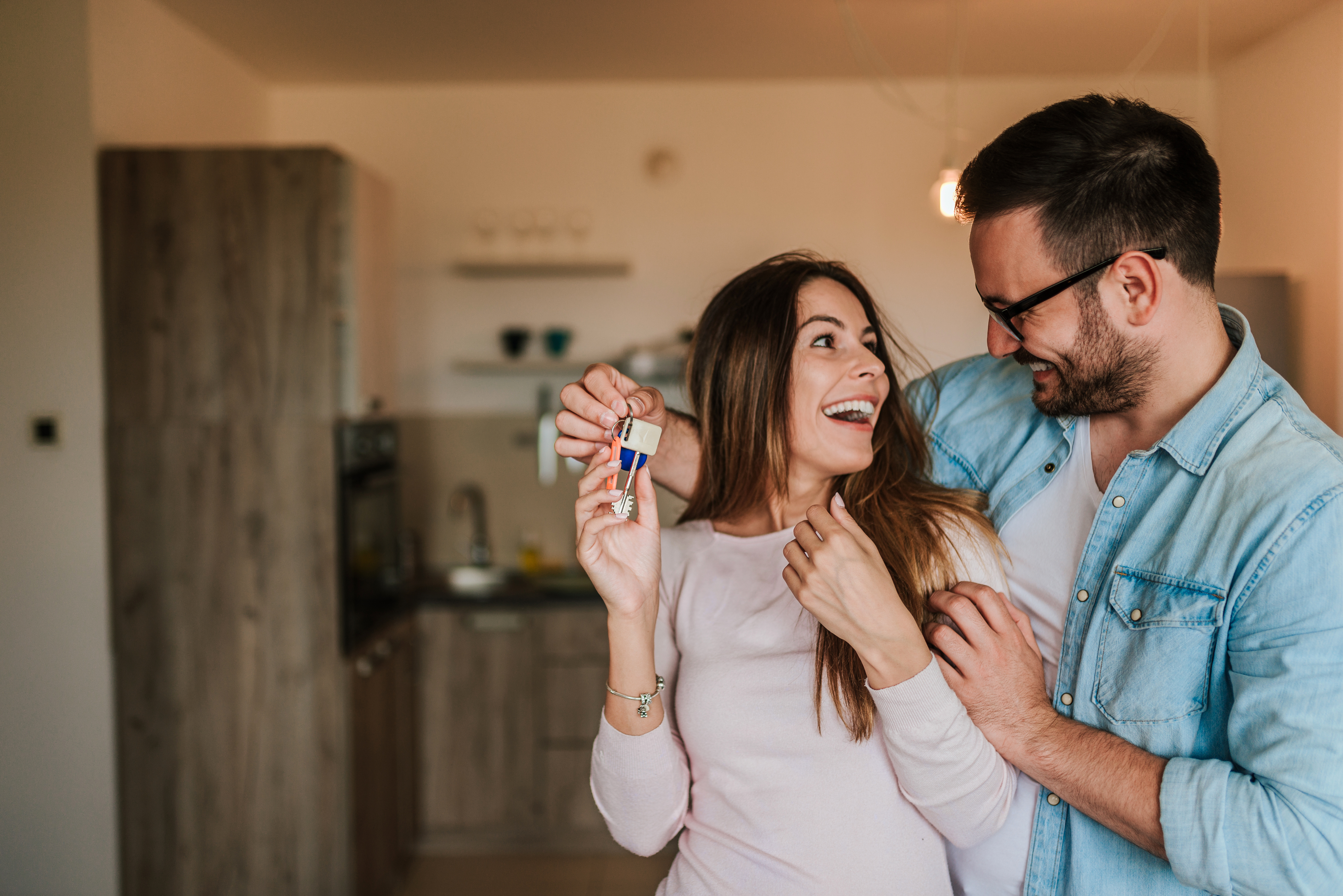 happy couple with keys to new house