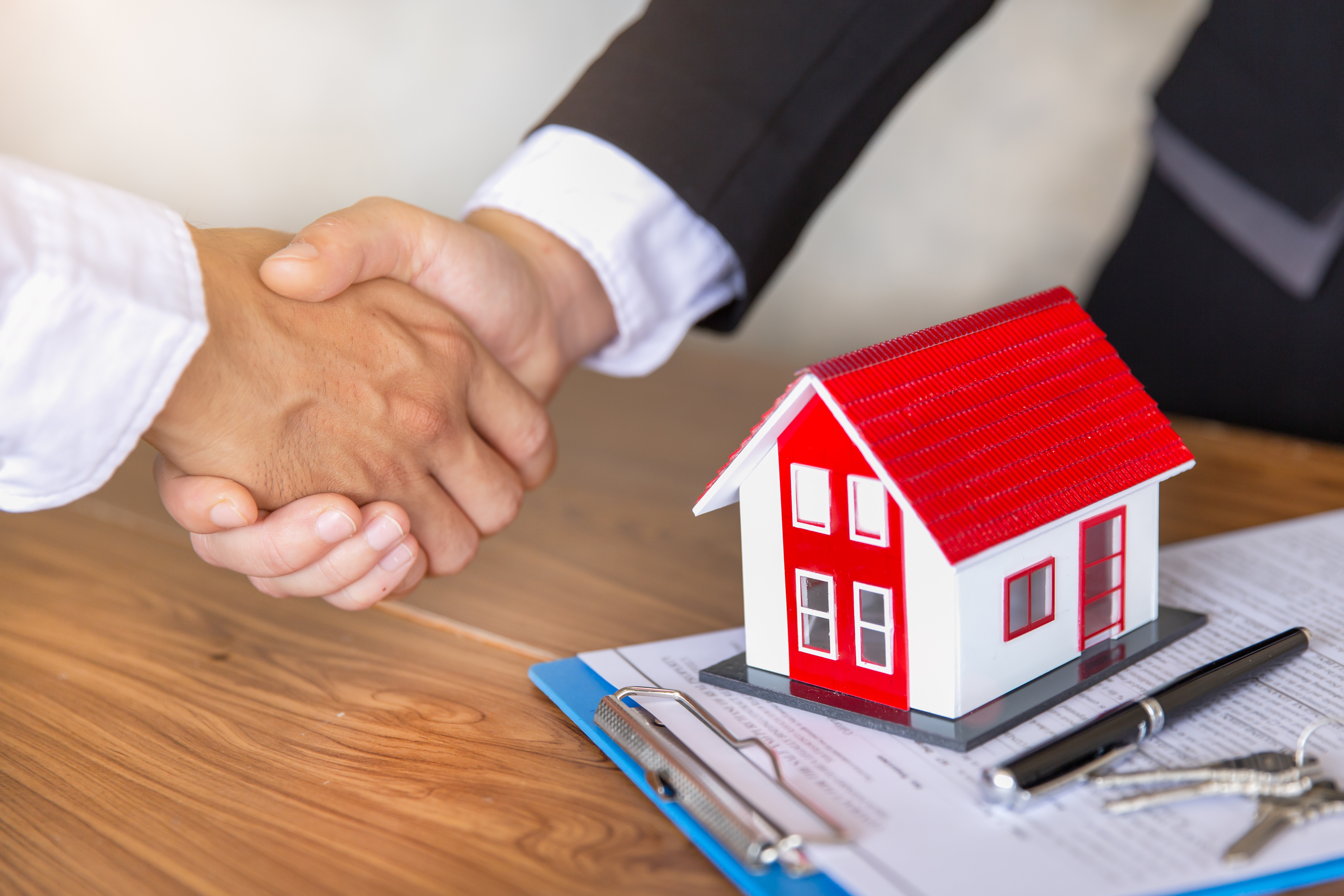 Estate agent shaking hands with customer after contract signature