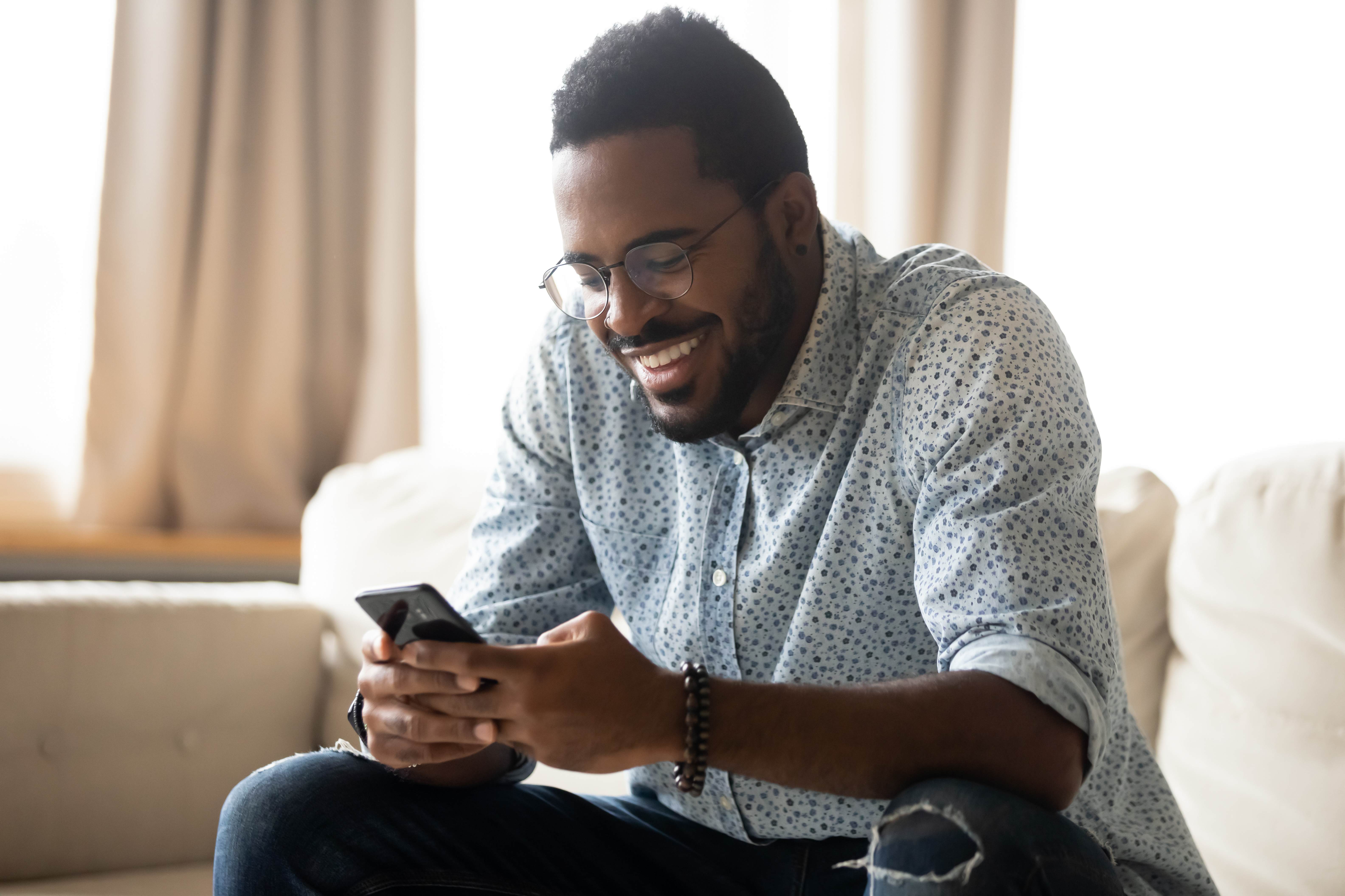 man smiling looking at phone