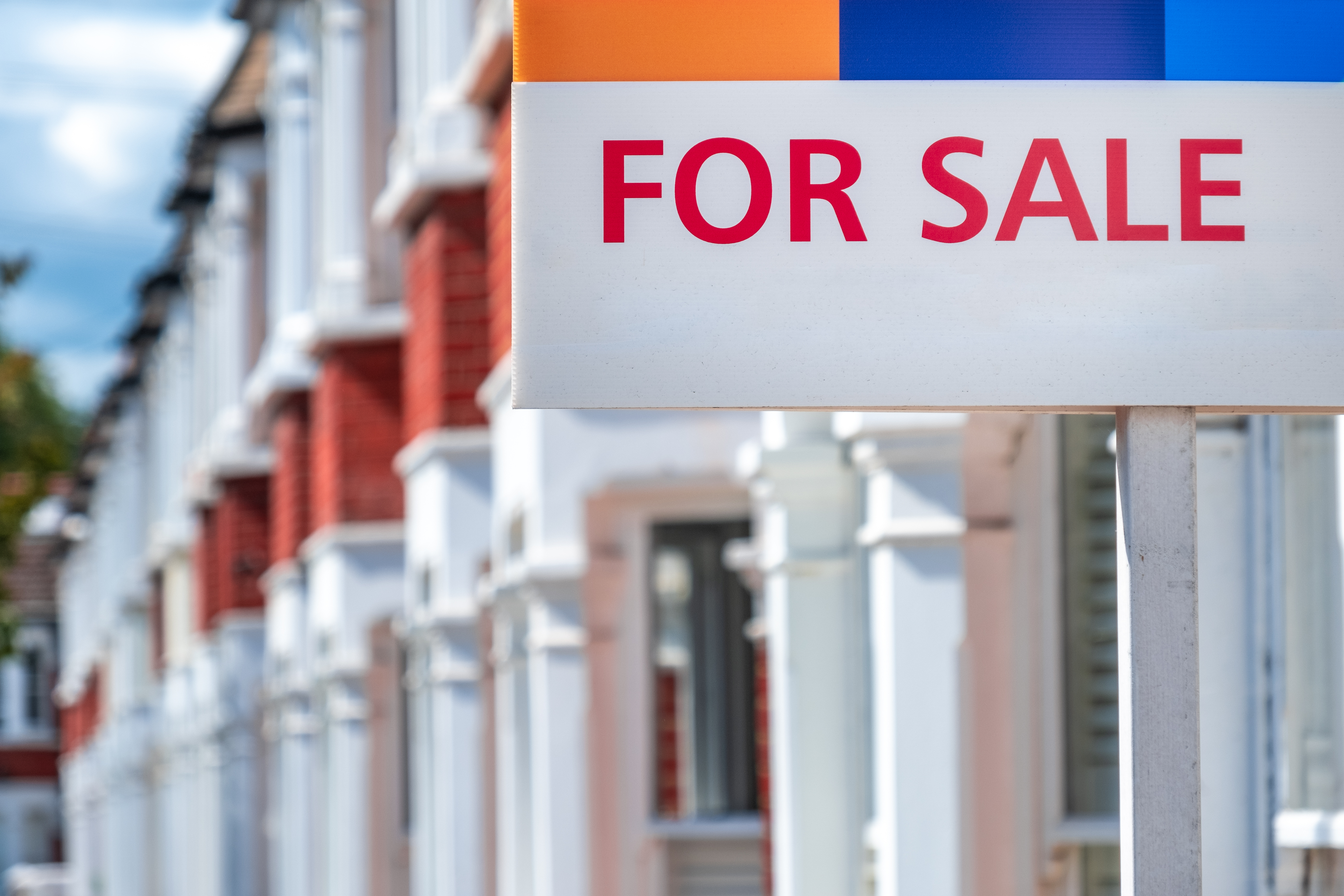 row of houses for sale sign